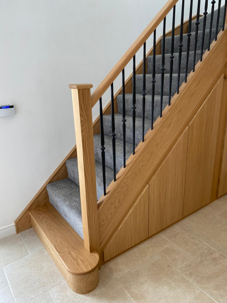 Пример оригинального дизайна: угловая лестница среднего размера в стиле модернизм с ступенями с ковровым покрытием, ковровыми подступенками и перилами из смешанных материалов