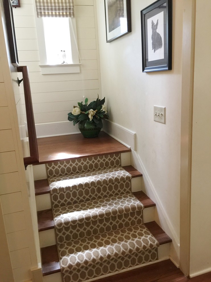 This is an example of a medium sized classic wood u-shaped staircase in Charleston with painted wood risers.