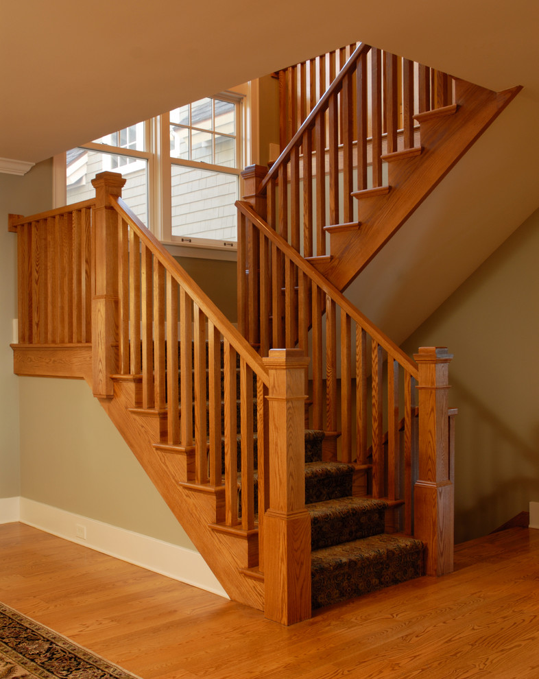 Cette photo montre un escalier tendance en U de taille moyenne avec des marches en moquette, des contremarches en moquette et un garde-corps en bois.