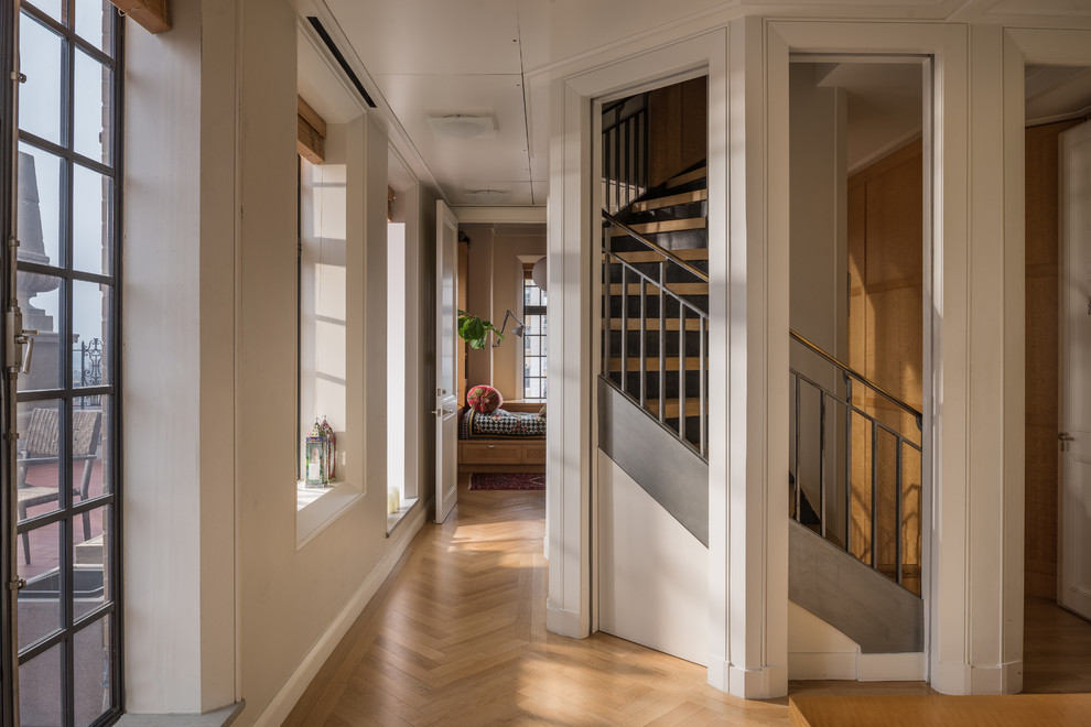 Источник вдохновения для домашнего уюта: изогнутая лестница в стиле фьюжн с деревянными ступенями и металлическими перилами