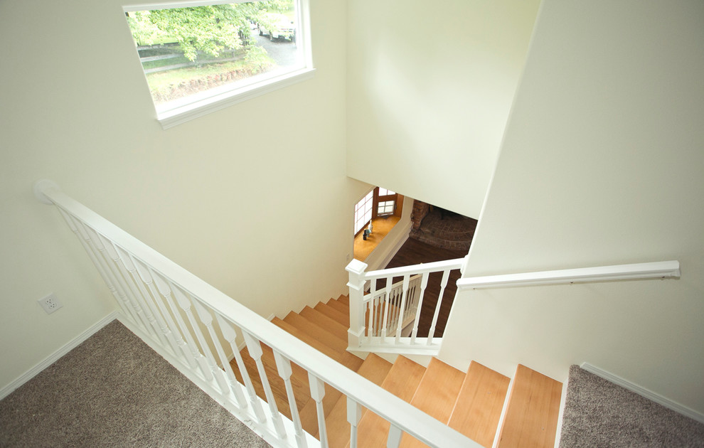 Mid-sized transitional wooden l-shaped wood railing staircase photo in Portland with painted risers