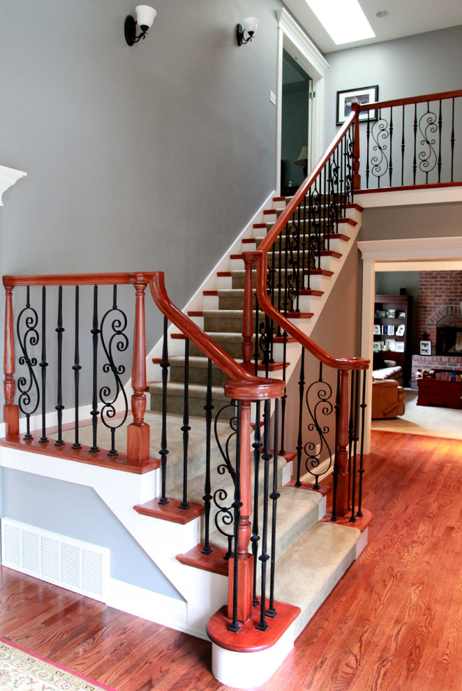 Inspiration pour un escalier traditionnel en L de taille moyenne avec des marches en moquette, des contremarches en bois et un garde-corps en matériaux mixtes.
