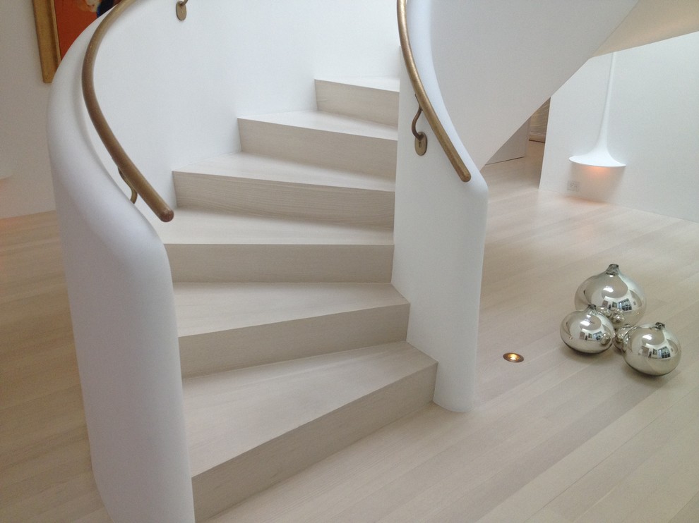 Inspiration for a large contemporary wood curved staircase in Orange County with wood risers.