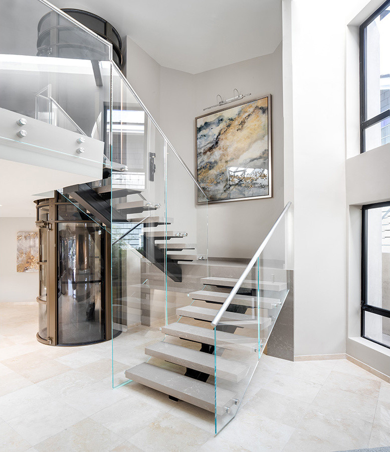 Inspiration for a large contemporary acrylic floating metal railing staircase in Orange County with concrete risers.