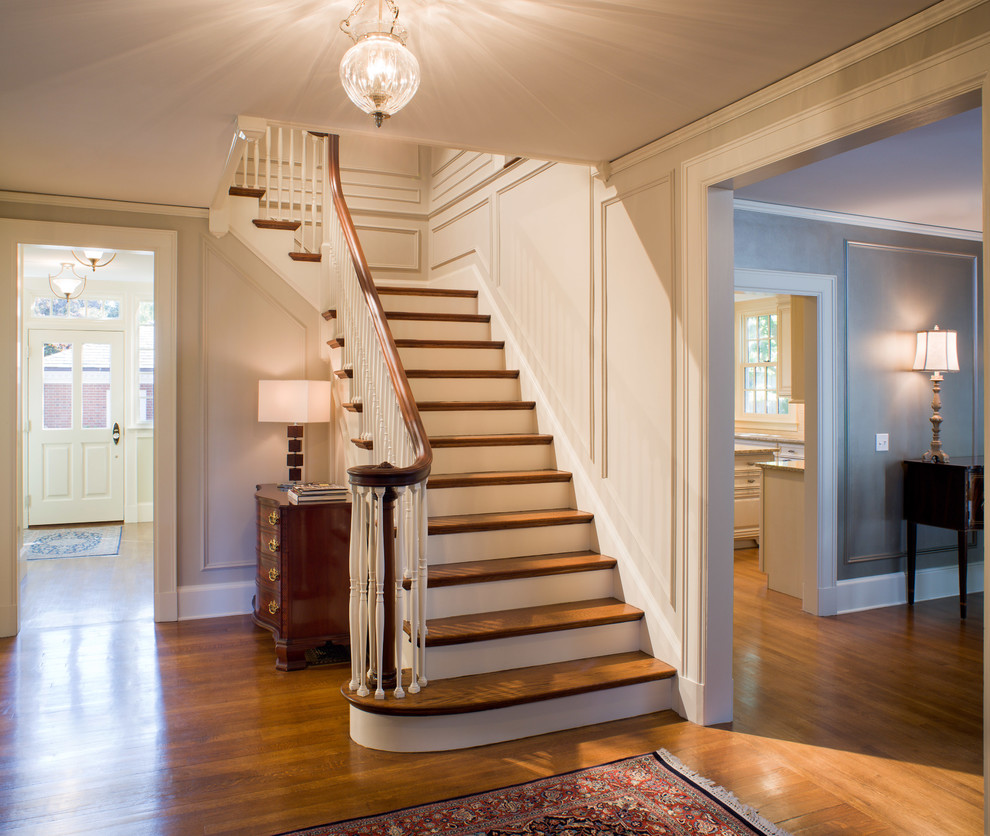 Aménagement d'un escalier peint classique en L de taille moyenne avec des marches en bois, un garde-corps en bois et éclairage.