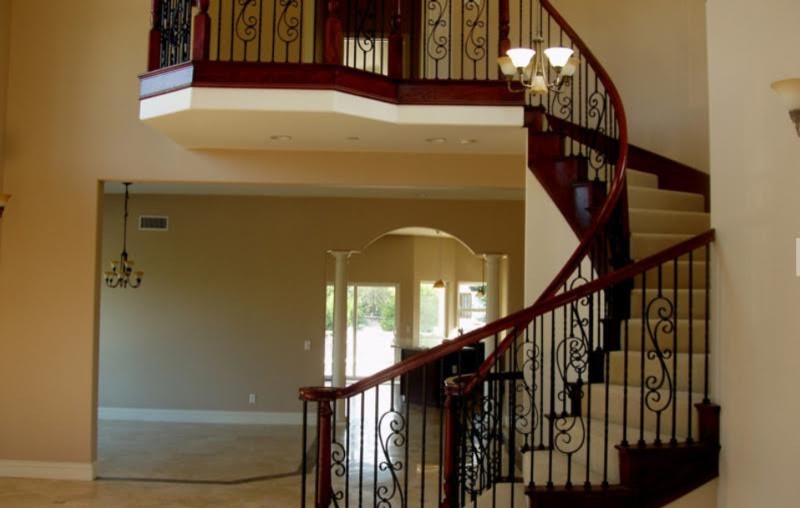 Источник вдохновения для домашнего уюта: большая изогнутая деревянная лестница в классическом стиле с деревянными ступенями и деревянными перилами