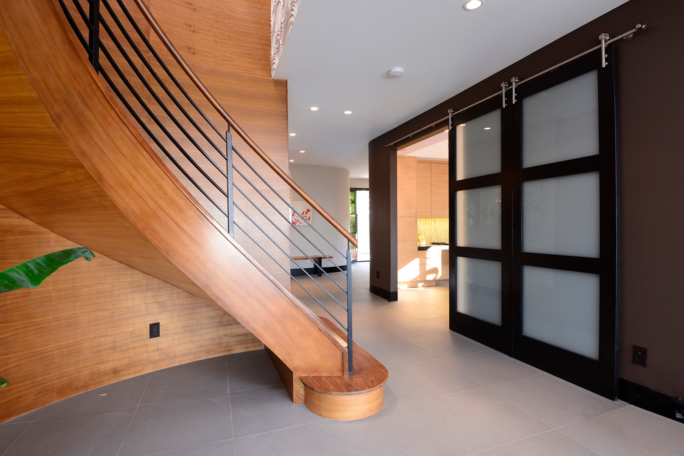 Ejemplo de escalera curva contemporánea de tamaño medio con escalones de madera y contrahuellas de madera