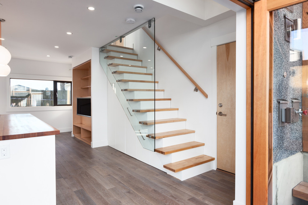 This is an example of a contemporary wood straight staircase in Vancouver with painted wood risers.