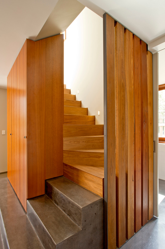 Aménagement d'un grand escalier moderne en L avec des marches en bois et des contremarches en bois.