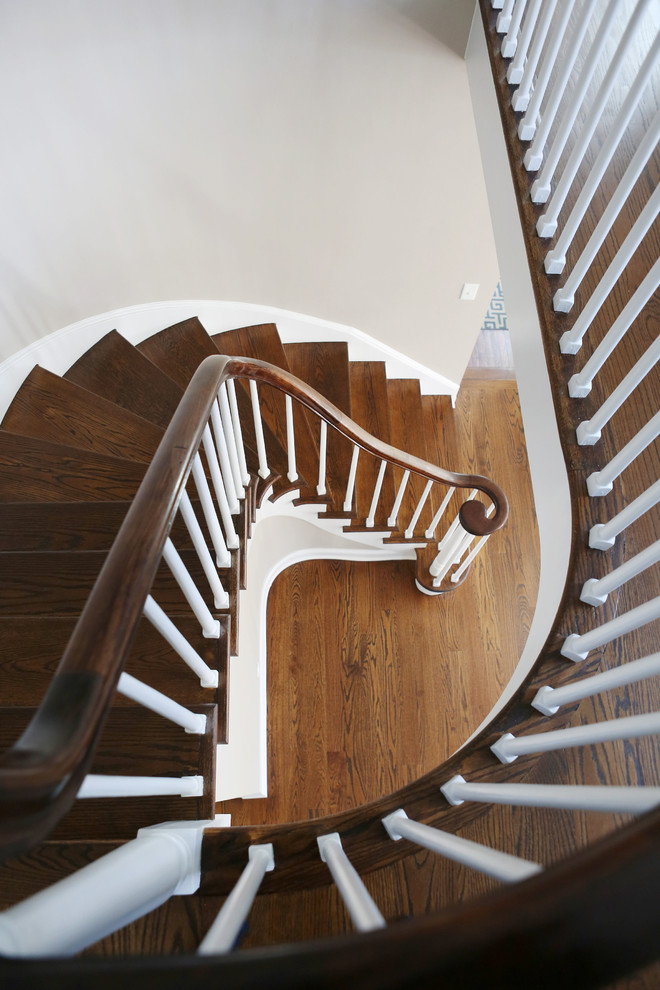 Foto de escalera curva clásica de tamaño medio con escalones de madera y contrahuellas de madera