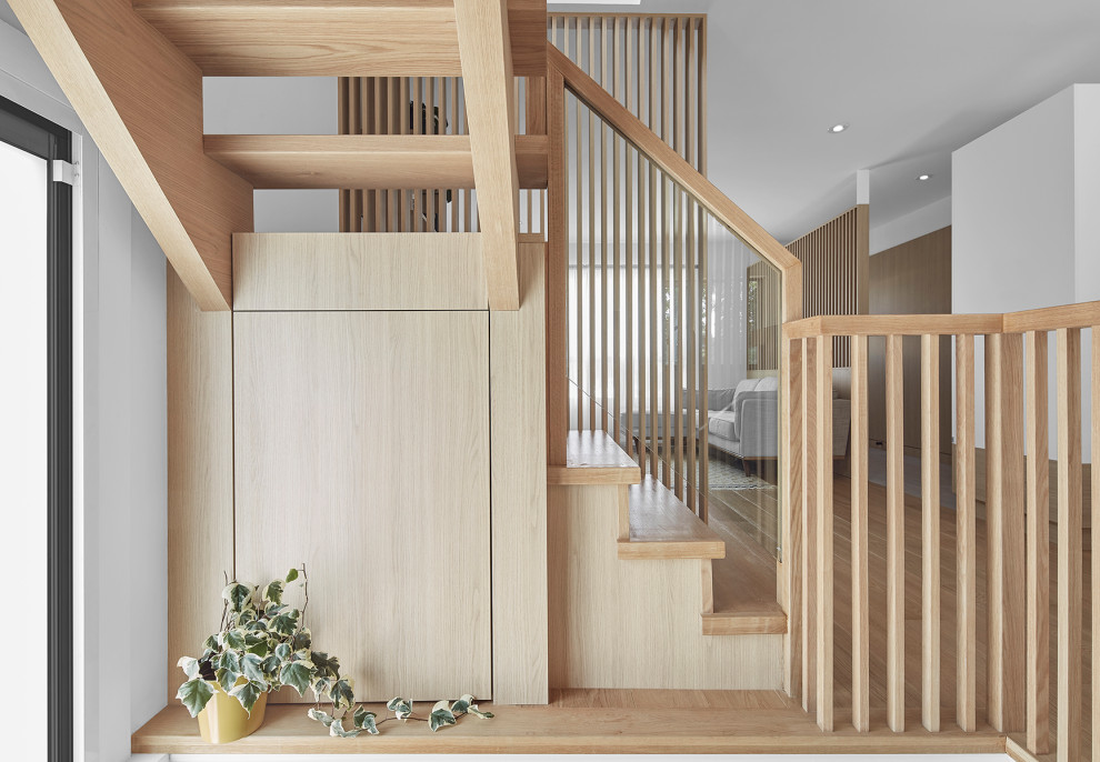 Diseño de escalera en U escandinava pequeña sin contrahuella con escalones de madera y barandilla de madera