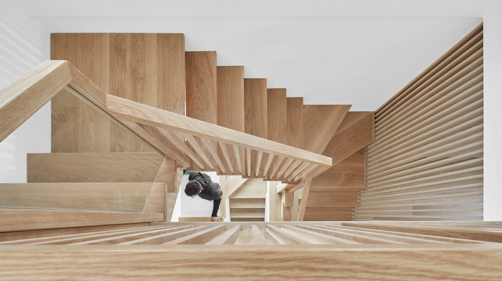 На фото: маленькая п-образная лестница в скандинавском стиле с деревянными ступенями и деревянными перилами без подступенок для на участке и в саду с