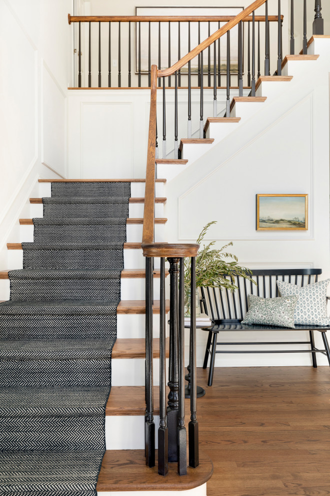 Traditional wood l-shaped wood railing staircase in Minneapolis with painted wood risers and panelled walls.