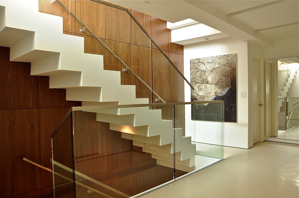 Cette photo montre un escalier droit moderne avec un garde-corps en verre.
