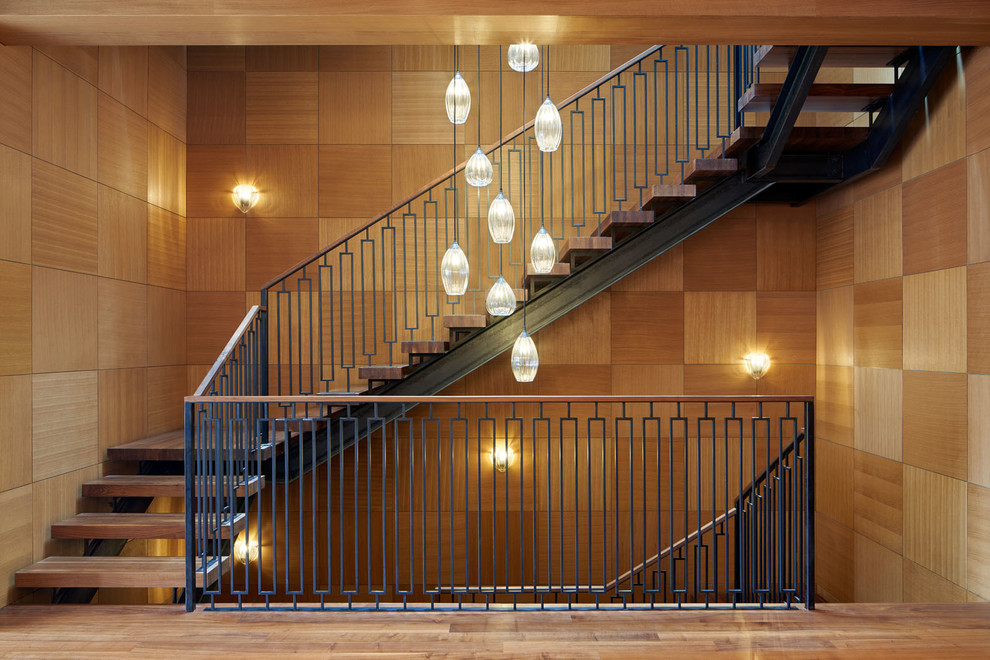 На фото: п-образная лестница в стиле неоклассика (современная классика) с деревянными ступенями и металлическими перилами без подступенок с