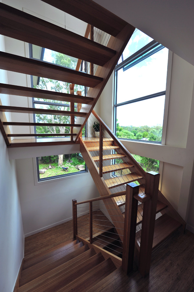 На фото: большая п-образная лестница в современном стиле с деревянными ступенями с