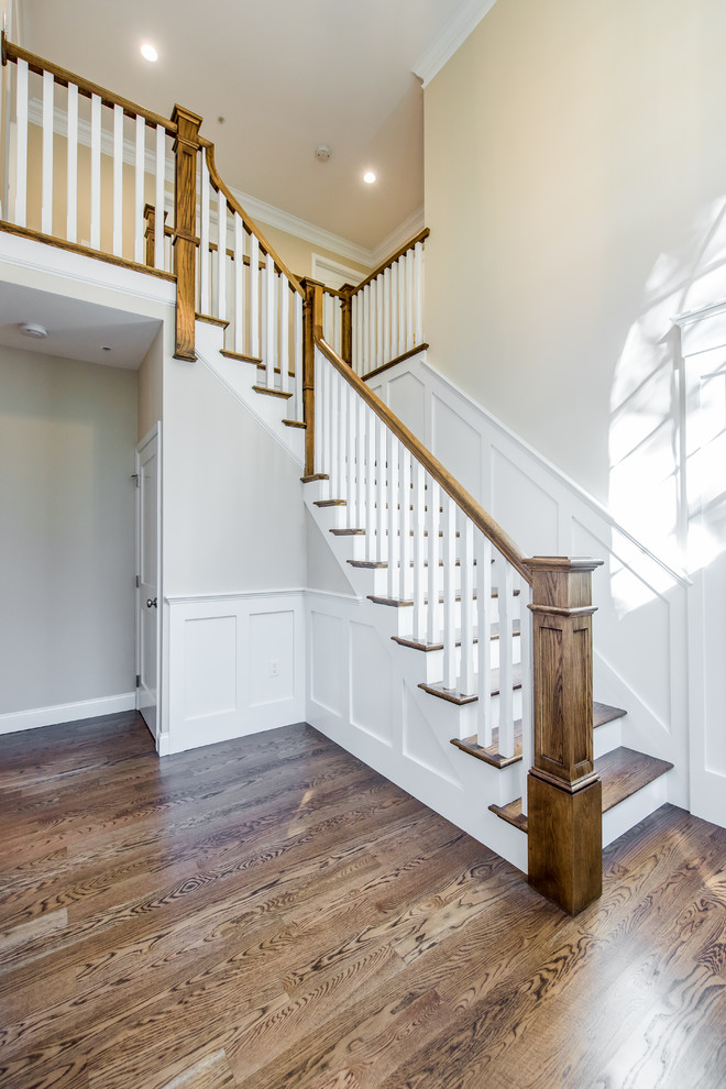 Imagen de escalera en L clásica de tamaño medio con escalones de madera y contrahuellas de madera pintada