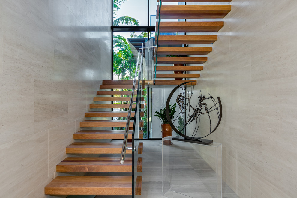 Diseño de escalera en U contemporánea sin contrahuella con escalones de madera y barandilla de vidrio