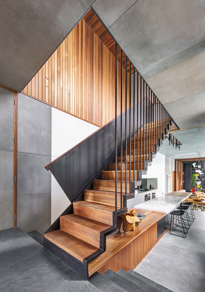 Idée de décoration pour un escalier droit design avec des marches en bois, des contremarches en bois et un garde-corps en matériaux mixtes.