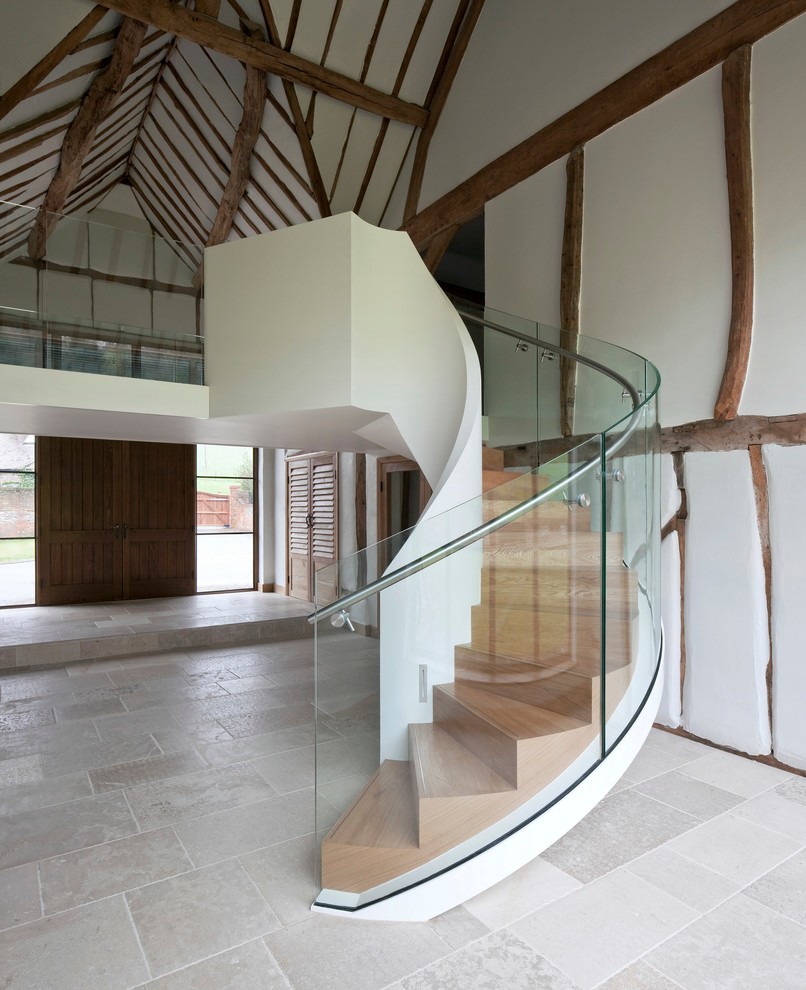 Ejemplo de escalera curva de estilo de casa de campo con escalones de madera y contrahuellas de metal