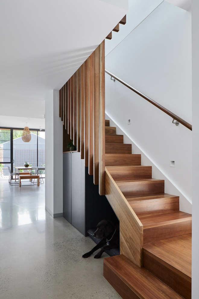 Imagen de escalera en L contemporánea de tamaño medio con escalones de madera, contrahuellas de madera y barandilla de madera