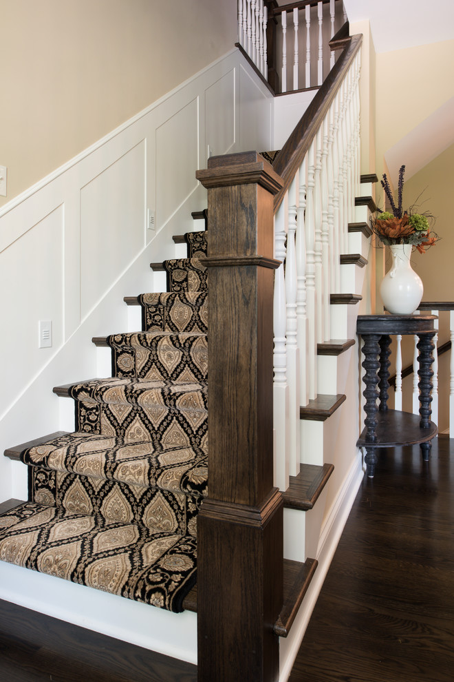 This is an example of a large classic wood l-shaped wood railing staircase in Minneapolis with wood risers.