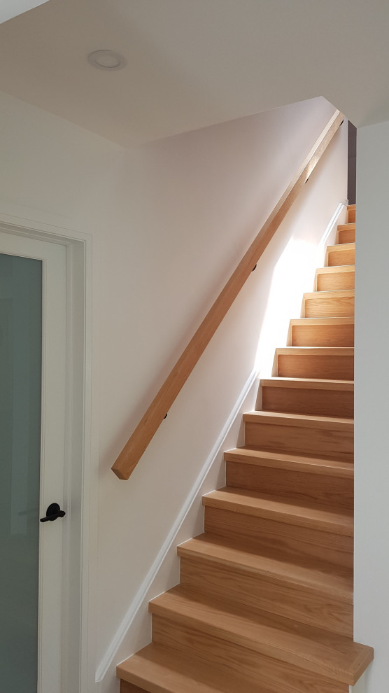 Imagen de escalera recta vintage de tamaño medio con escalones de madera, contrahuellas de madera y barandilla de madera
