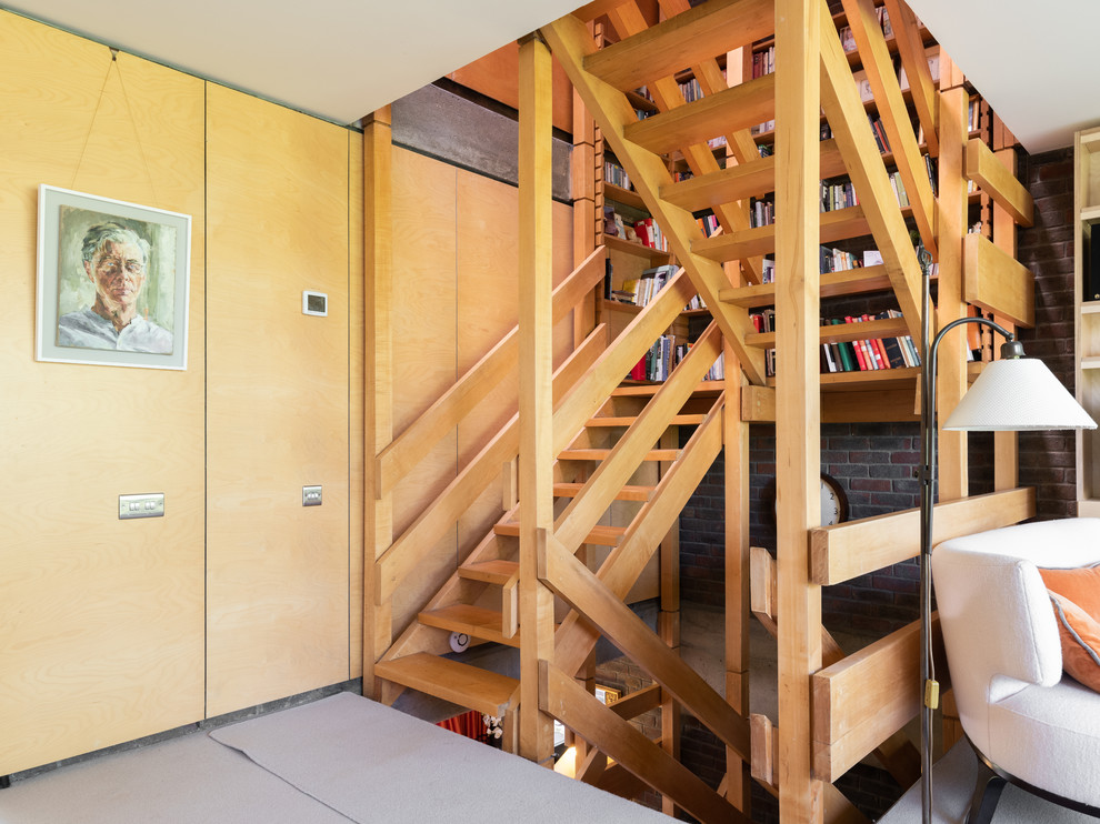 Foto de escalera en U retro de tamaño medio sin contrahuella con escalones de madera y barandilla de madera