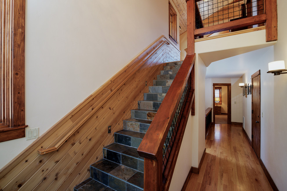 Foto de escalera recta de estilo americano de tamaño medio con escalones con baldosas, contrahuellas con baldosas y/o azulejos y barandilla de madera