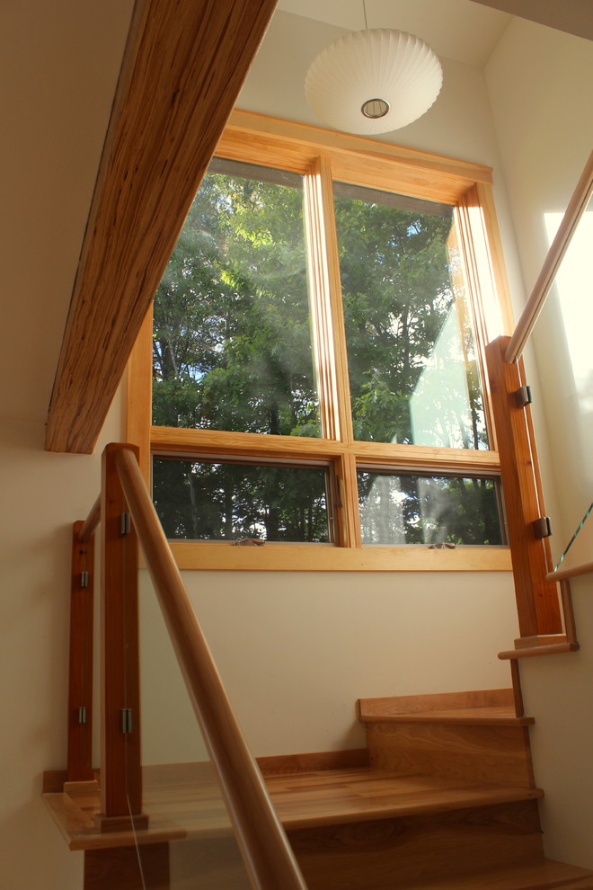 Ejemplo de escalera en L contemporánea de tamaño medio con escalones de madera, contrahuellas de madera y barandilla de varios materiales