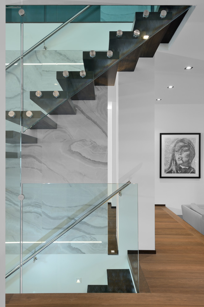 Réalisation d'un escalier sans contremarche flottant design avec un garde-corps en verre.