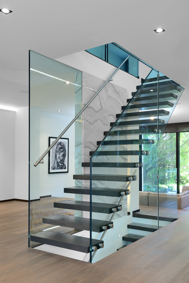 Пример оригинального дизайна: лестница на больцах в современном стиле с стеклянными перилами без подступенок