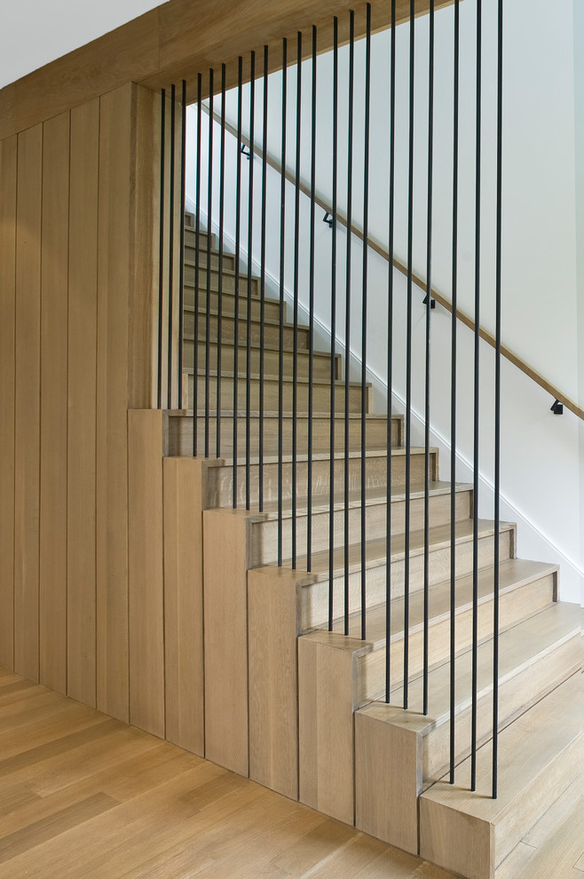 Example of a transitional wooden straight metal railing staircase design in New York with wooden risers