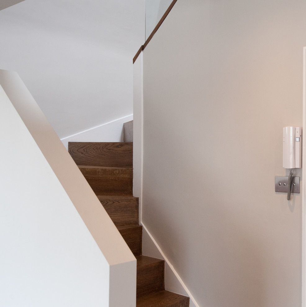Cette image montre un escalier courbe design de taille moyenne avec des marches en bois et des contremarches en bois.