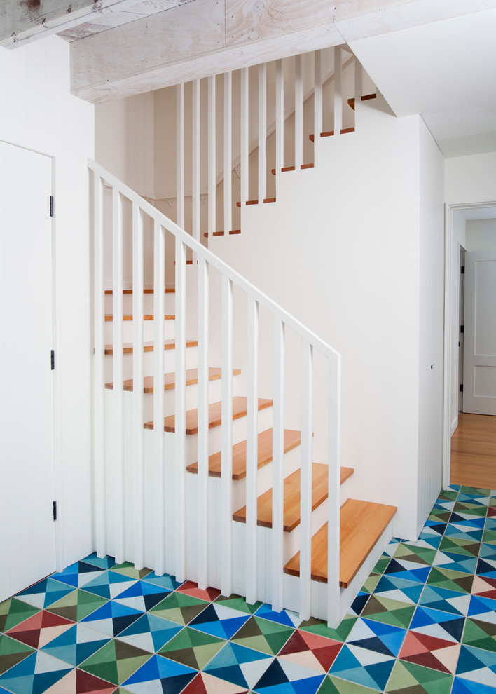 サンフランシスコにある北欧スタイルのおしゃれな折り返し階段 (木の蹴込み板、木材の手すり) の写真