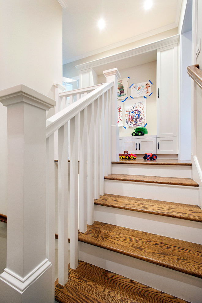 Foto de escalera en U tradicional de tamaño medio con escalones de madera, contrahuellas de madera y barandilla de madera