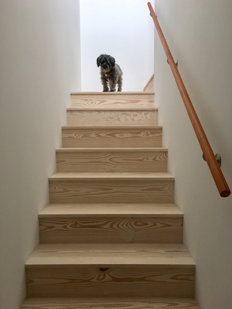 На фото: маленькая угловая лестница в стиле модернизм с крашенными деревянными ступенями, крашенными деревянными подступенками и деревянными перилами для на участке и в саду с