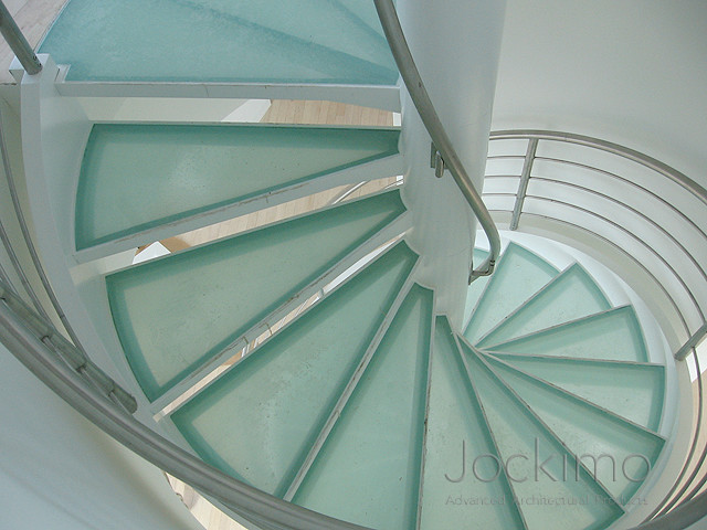 Imagen de escalera de caracol contemporánea con escalones de vidrio y contrahuellas de vidrio