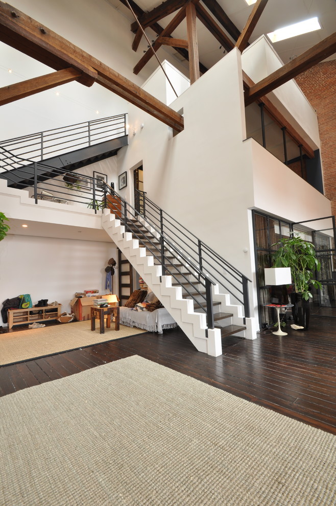 Cette photo montre un grand escalier sans contremarche industriel avec des marches en bois et un garde-corps en métal.