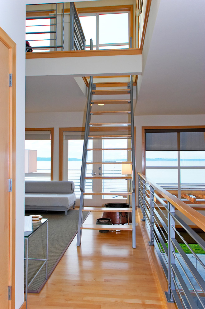 Imagen de escalera recta moderna de tamaño medio con escalones de madera y barandilla de metal