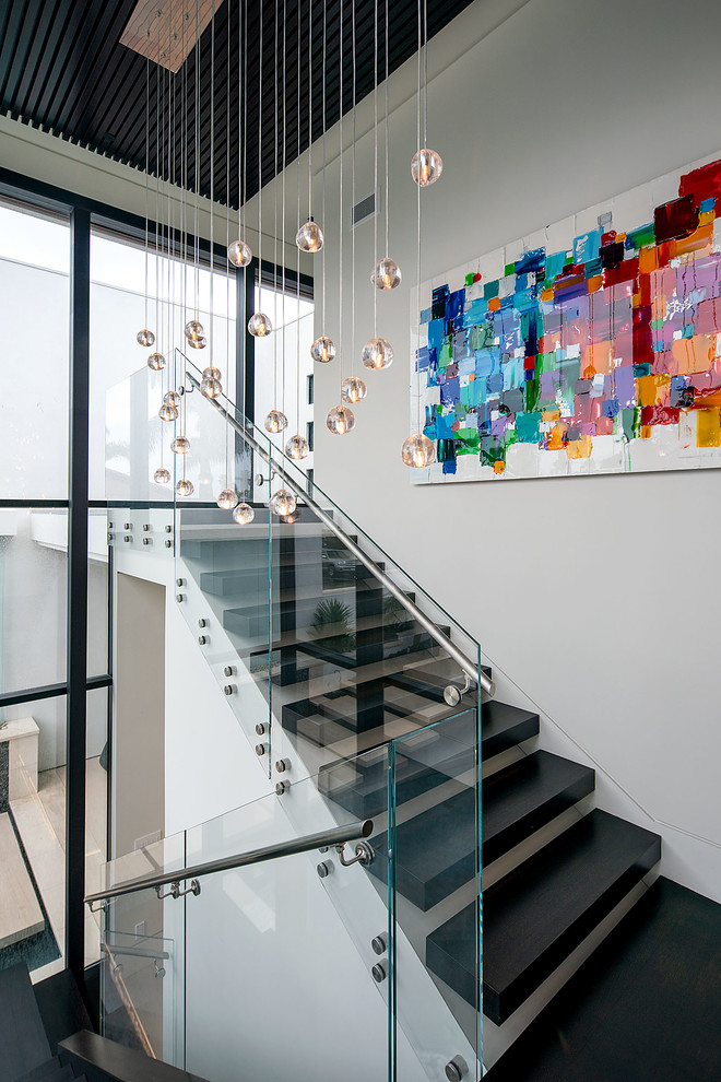 Идея дизайна: лестница среднего размера в стиле модернизм с деревянными ступенями и стеклянными подступенками
