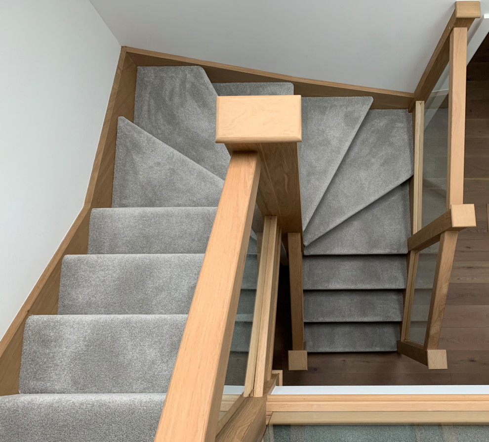 Diseño de escalera en U actual de tamaño medio con escalones enmoquetados, contrahuellas enmoquetadas y barandilla de varios materiales