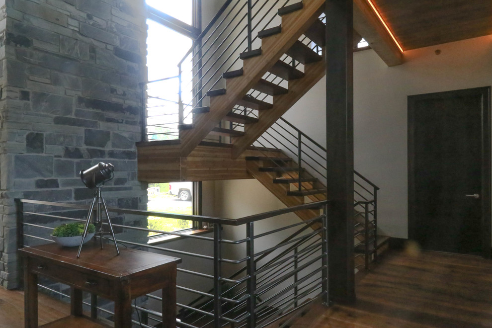 Aménagement d'un grand escalier sans contremarche classique en U avec des marches en bois et un garde-corps en matériaux mixtes.