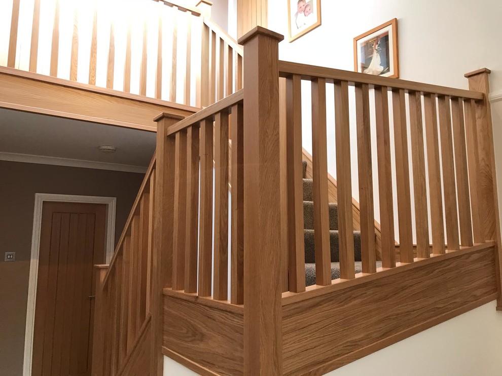Medium sized contemporary carpeted u-shaped wood railing staircase in Manchester with carpeted risers.