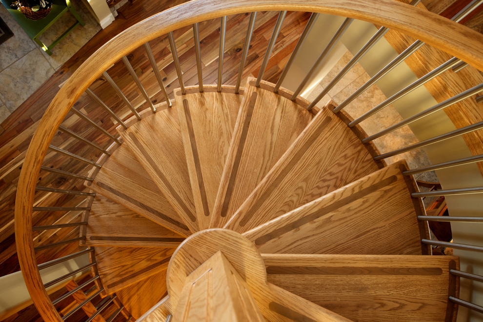 Foto de escalera de caracol de estilo americano con escalones de madera, contrahuellas de madera y barandilla de varios materiales
