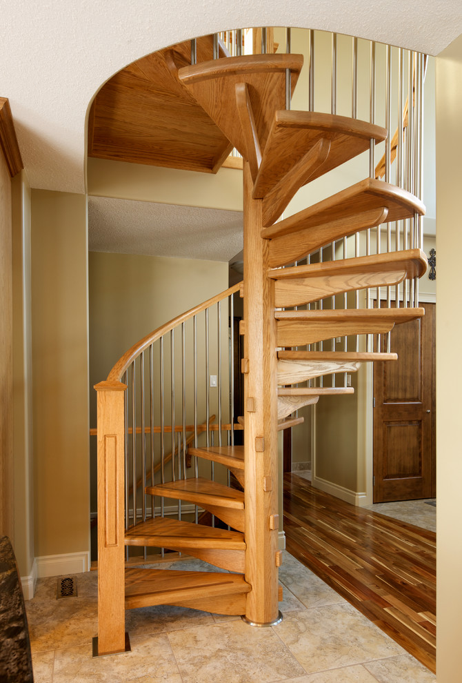 Imagen de escalera de caracol rural sin contrahuella con escalones de madera y barandilla de varios materiales