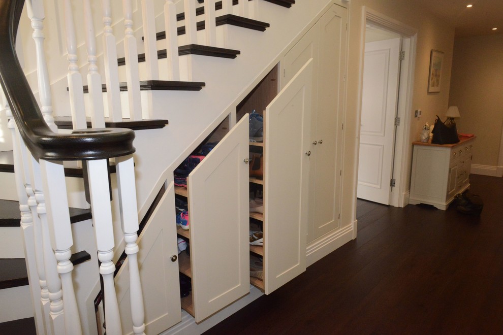 Idée de décoration pour un escalier courbe design de taille moyenne avec des marches en bois, des contremarches en bois et rangements.