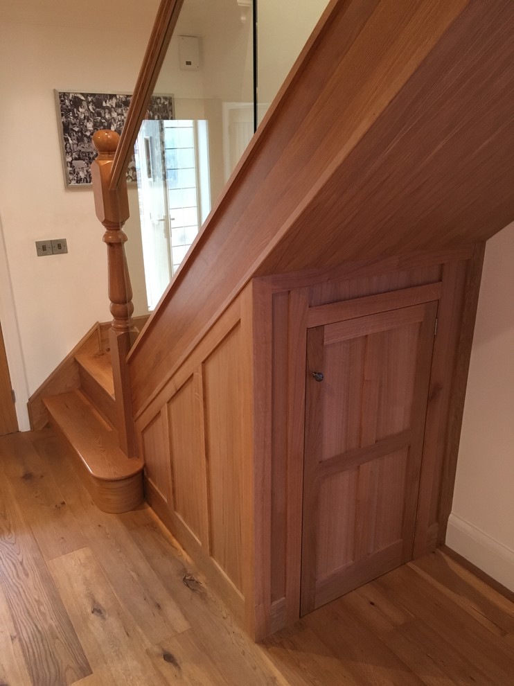 This is an example of a large modern wood straight wood railing staircase in Essex with wood risers.