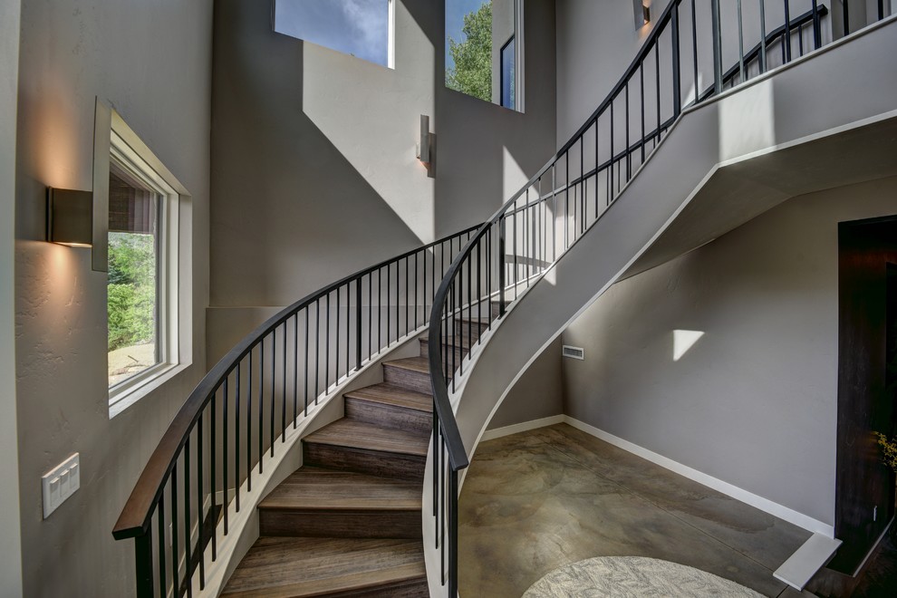 Идея дизайна: изогнутая деревянная лестница среднего размера в стиле модернизм с деревянными ступенями и металлическими перилами