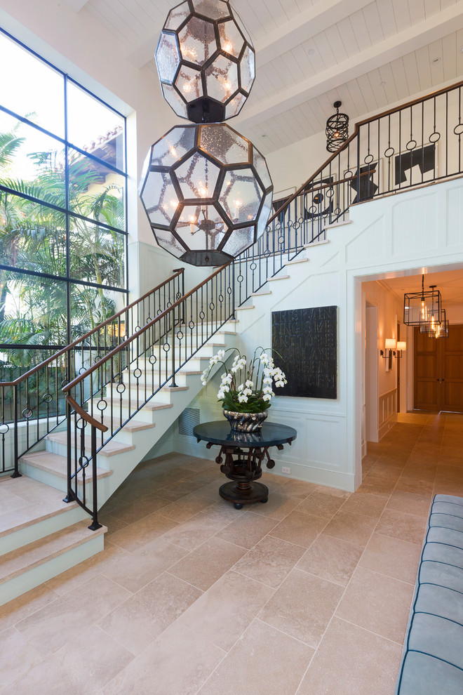 На фото: лестница в средиземноморском стиле с ступенями из плитки, крашенными деревянными подступенками и металлическими перилами